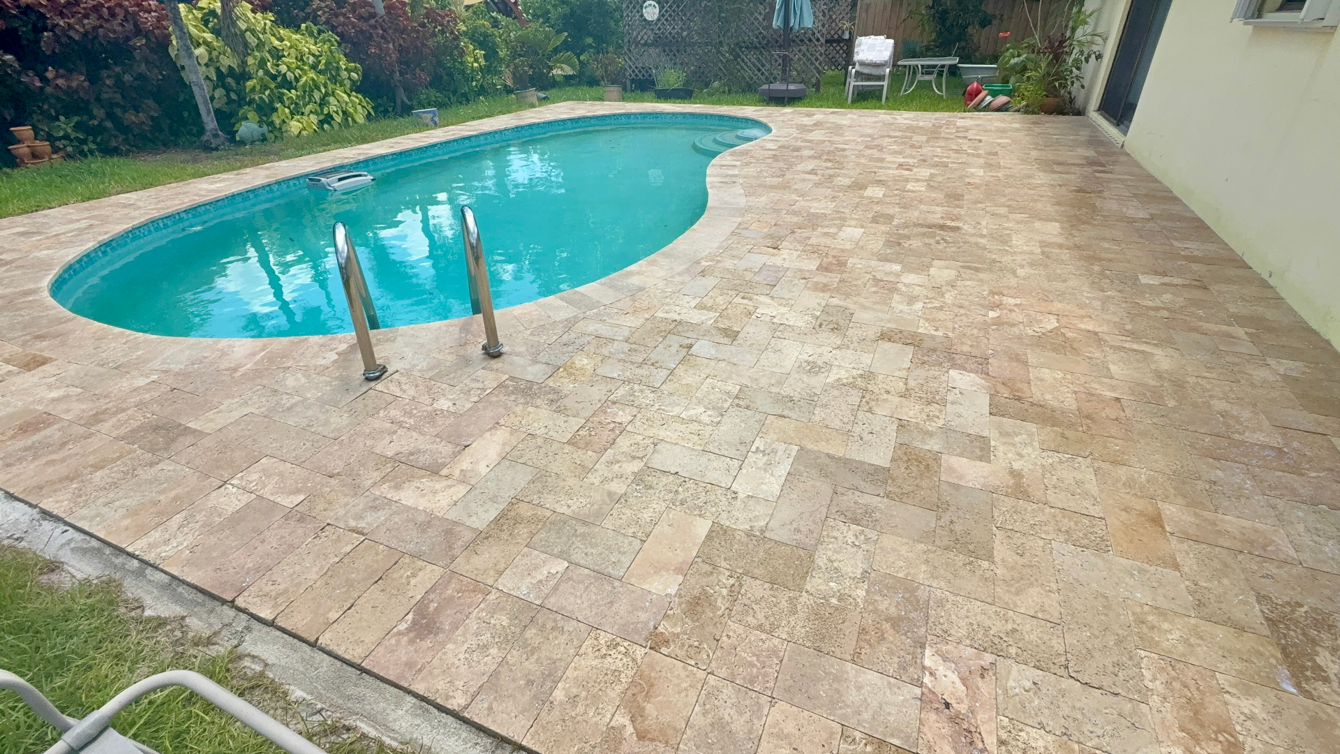 Freshly sealed travertine pool deck in South Florida