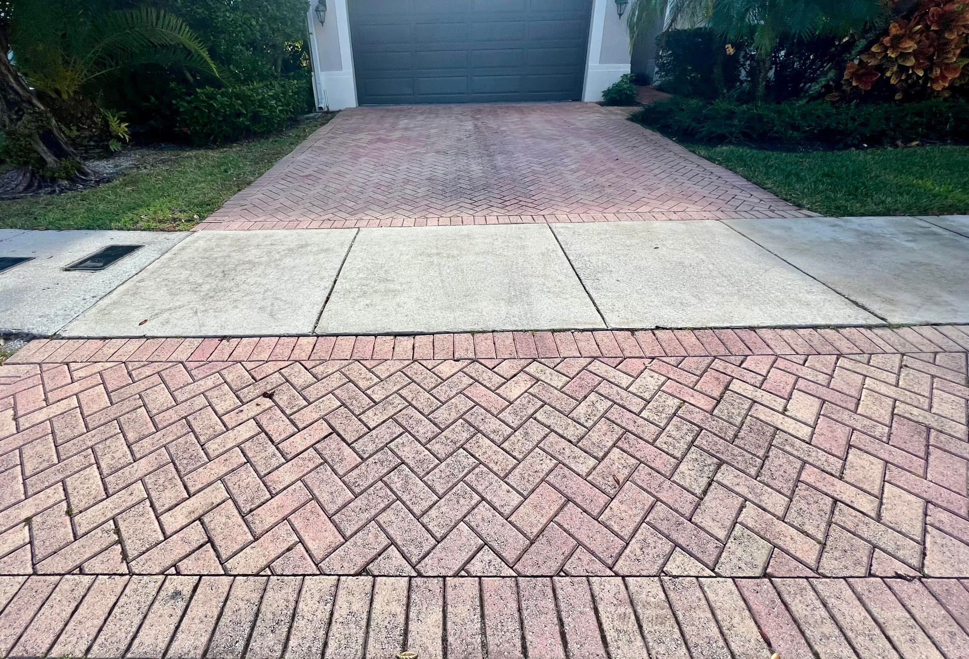 Faded herringbone brick paver driveway before sealing